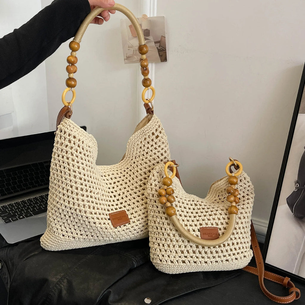 Knitted large capacity tote beach bag in bucket shape with contrast stitching and crossbody strap, black colour, on a plain background