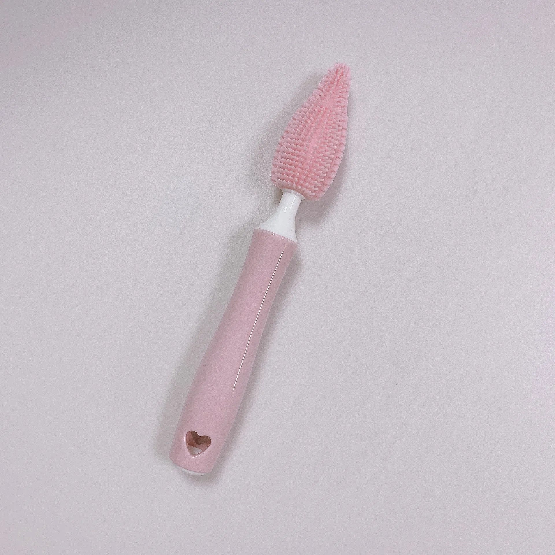 Three-piece silicone baby bottle brush set in pink, blue, and yellow with straw cleaning tool