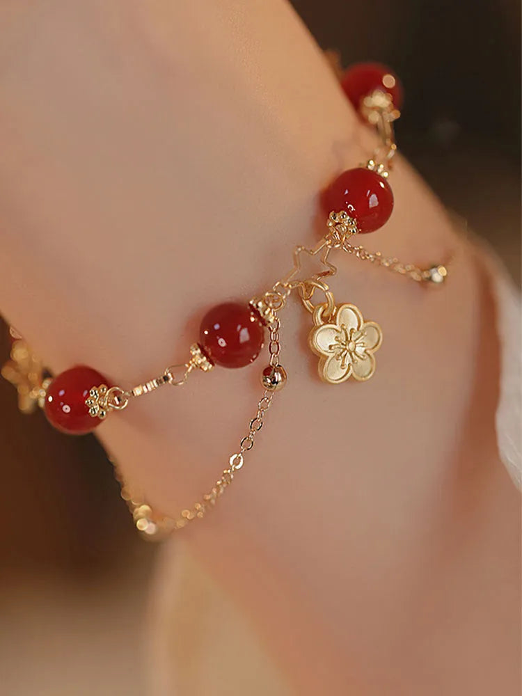 Red agate double layer bracelet with floral and peach blossom charms on adjustable band