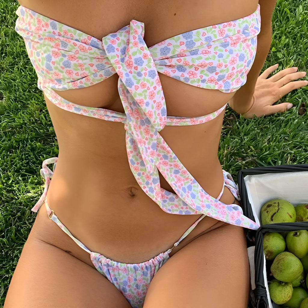 Women's wireless padded swimsuit with front lace-up detail on a split, shown in a small floral print.