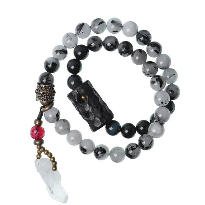 Ethnic style black hair crystal bracelet with white crystal tassel and bending lacing closure on plain background