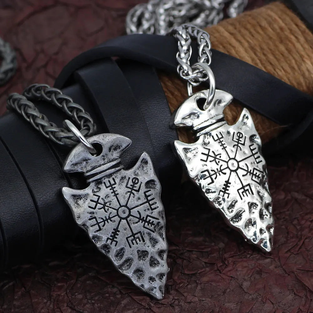Alloy compass pendant necklace with twisted chain on a flat surface showing silver finish