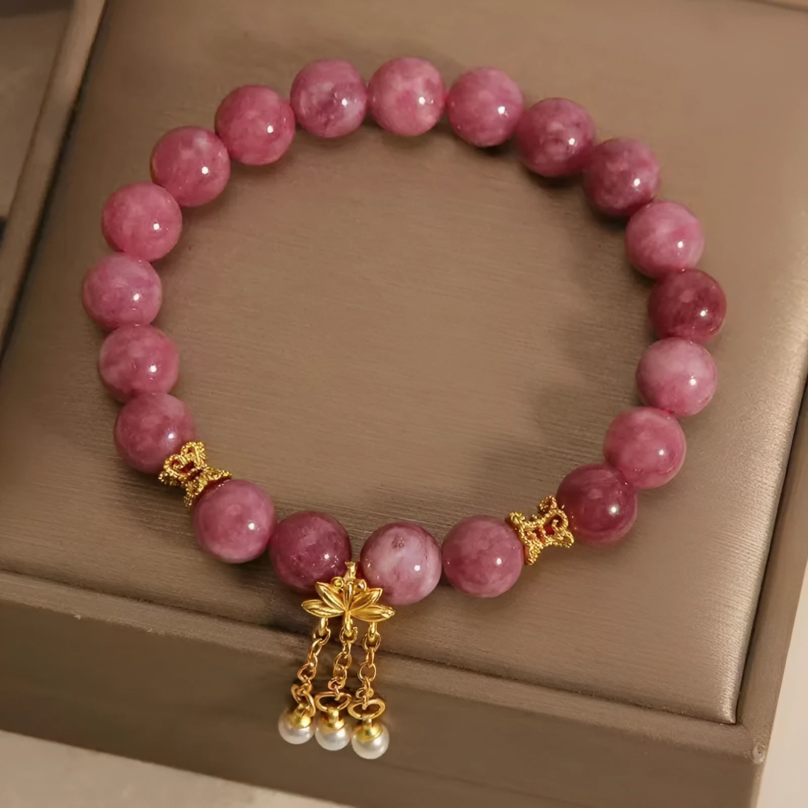 Natural stone beaded bracelet with pink lotus tassel and pearl pendant on white background
