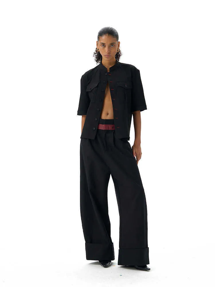 Handmade black loose fit half sleeve hunting shirt with a shirt collar, laid flat.
